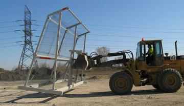 A friont-end loader moving The Bull litter fencing into position.